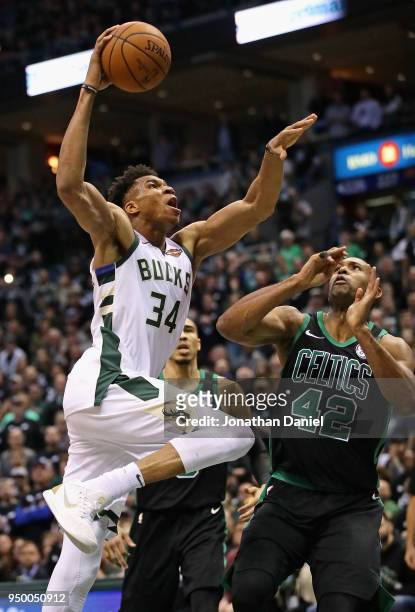 Giannis Antetokounmpo of the Milwaukee Bucks goes up for a dunk over Al Horford of the Boston Celtics during Game Four of Round One of the 2018 NBA...