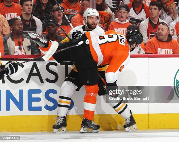 Bryan Rust of the Pittsburgh Penguins is checked by Robert Hagg of the Philadelphia Flyers during the first period in Game Six of the Eastern...