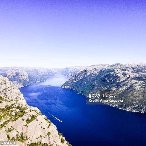 lysefjord or lysefjorden is a fjord located in the ryfylke area in southwestern norway. view of the fjord from the huge preikestolen cliff, which is a major tourist destination for the region. nature background. image with copy space. - fjord der berge stock-fotos und bilder