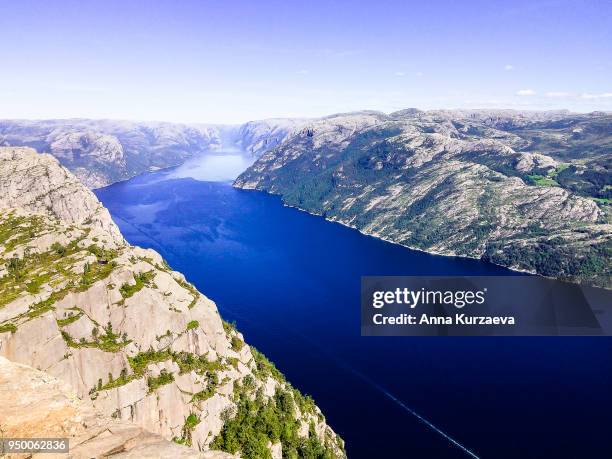 lysefjord or lysefjorden is a fjord located in the ryfylke area in southwestern norway. view of the fjord from the huge preikestolen cliff, which is a major tourist destination for the region. nature background. image with copy space. - fjord der berge stock-fotos und bilder