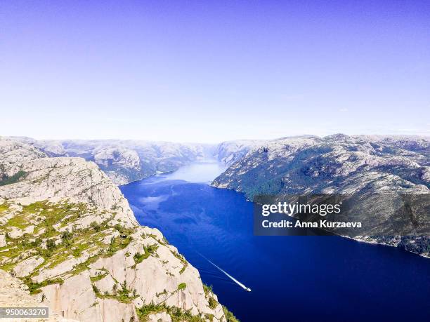 lysefjord or lysefjorden is a fjord located in the ryfylke area in southwestern norway. view of the fjord from the huge preikestolen cliff, which is a major tourist destination for the region. nature background. image with copy space. - fjord der berge stock-fotos und bilder