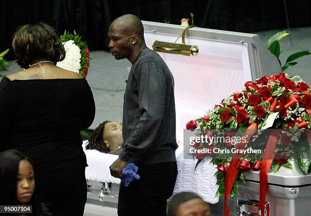 Chad Ochocinco of the Cincinnati Bengals stands next to the open casket during the funeral for Cincinnati Bengals player Chris Henry at the Alario...