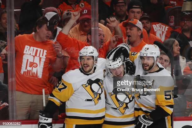 Jake Guentzel of the Pittsburgh Penguins celebrates his goal at 12:58 of the third period against the Philadelphia Flyers and is joined by Sidney...