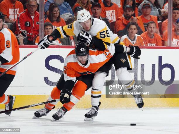 Jake Guentzel of the Pittsburgh Penguins attempts to get past Andrew MacDonald of the Philadelphia Flyers during the third period in Game Six of the...