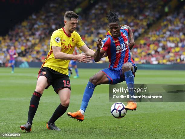 Wilfred Zaha of Palace is challenged by Craig Cathcart of Watford during the Premier League match between Watford and Crystal Palace at Vicarage Road...