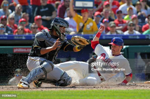 Andrew Knapp of the Philadelphia Phillies slides safely into home plate as catcher Elias Diaz of the Pittsburgh Pirates fields the throw in the fifth...