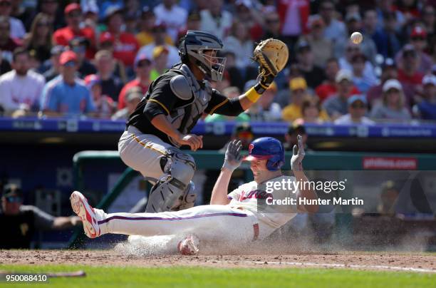 Starting pitcher Nick Pivetta of the Philadelphia Phillies slides safely into home plate as catcher Elias Diaz of the Pittsburgh Pirates fields the...
