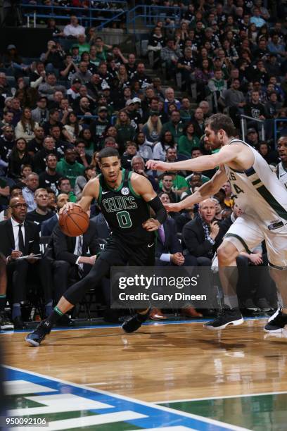 Jayson Tatum of the Boston Celtics handles the ball against Tyler Zeller of the Milwaukee Bucks in Game Four of Round One of the 2018 NBA Playoffs on...