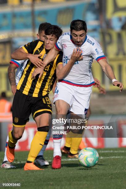 Nacional's Jorge Fucile vies for the ball with Penarol's Agustin Canobbio during Uruguay's football derby at the Centenario stadium in Montevideo on...