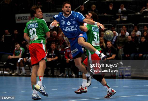 Drago Vukovic of Gummersbach is challenged by Fabian van Olphen and Bartosz Jurecki of Magdeburg during the Toyota Handball Bundesliga match between...