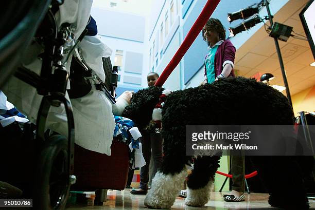 Malia Obama and Sasha Obama take their dog Bo around to visit patients while at the Children's National Medical Center with their mother, first lady...