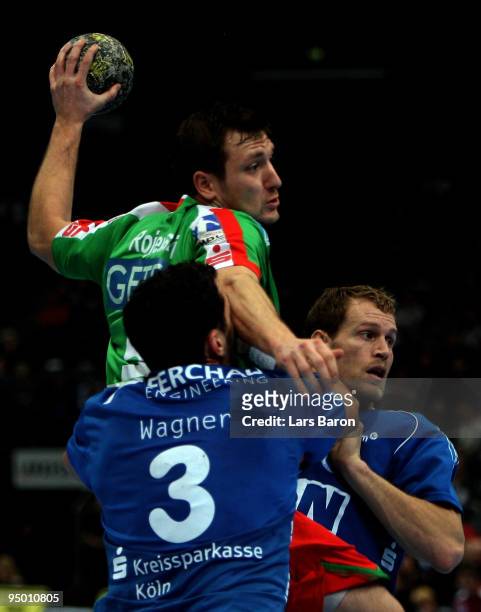 Andreas Rojewski of Magdeburg is challenged by Adrian Wagner and Geoffroy Krantz of Gummersbach during the Toyota Handball Bundesliga match between...