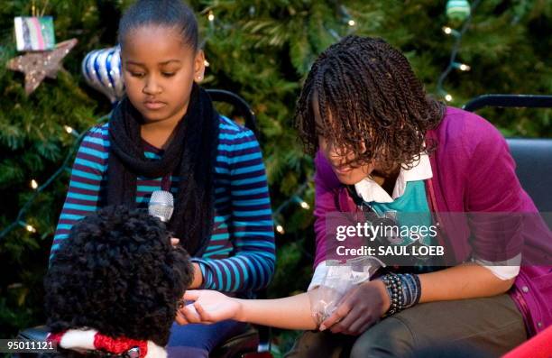 Malia Obama and Sasha Obama , daughters of US President Barack Obama, play with their dog Bo, during a visit to the Children's National Medical...