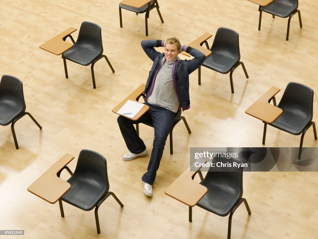 Seguro de college student sentado en la mesa en montaje tipo aula