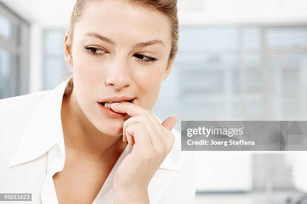 businesswoman biting fingernails - nail biting stock pictures, royalty-free photos & images