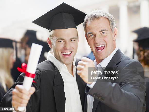 father and graduate son celebrating - son graduation stock pictures, royalty-free photos & images