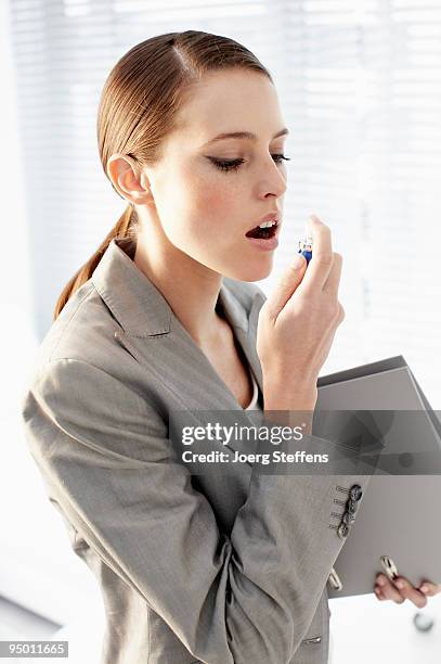 businesswoman using breath spray - mouth spray stock pictures, royalty-free photos & images