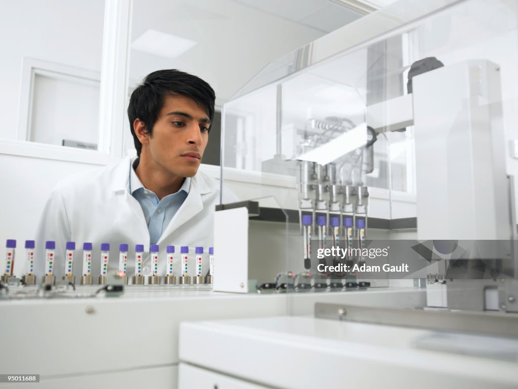 Scientist watching test tubes in machine