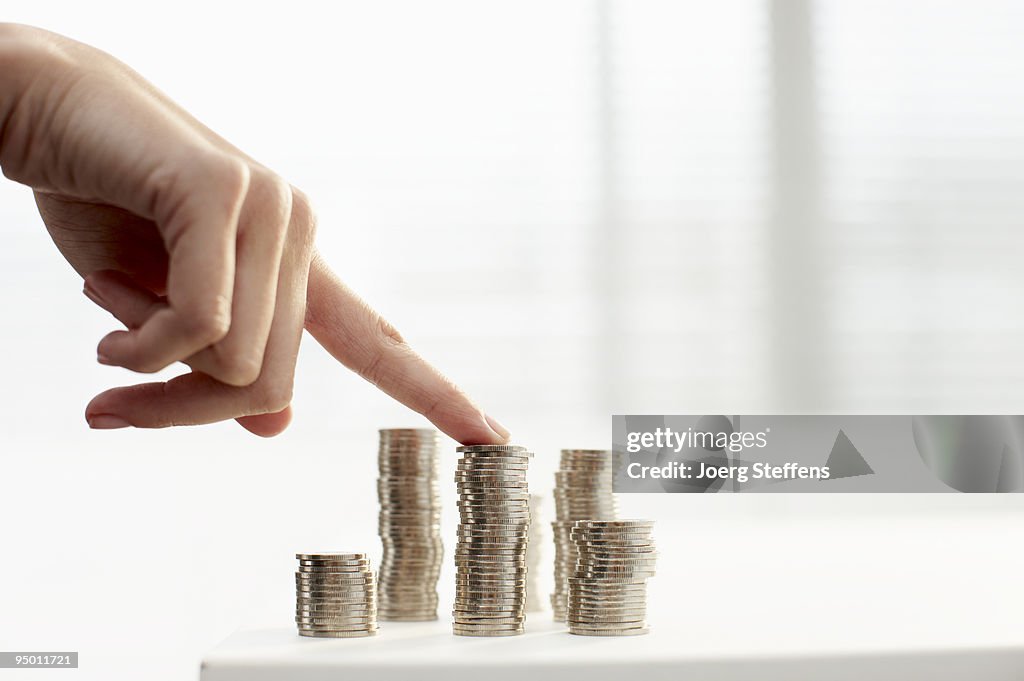 Womans finger on stack of coins