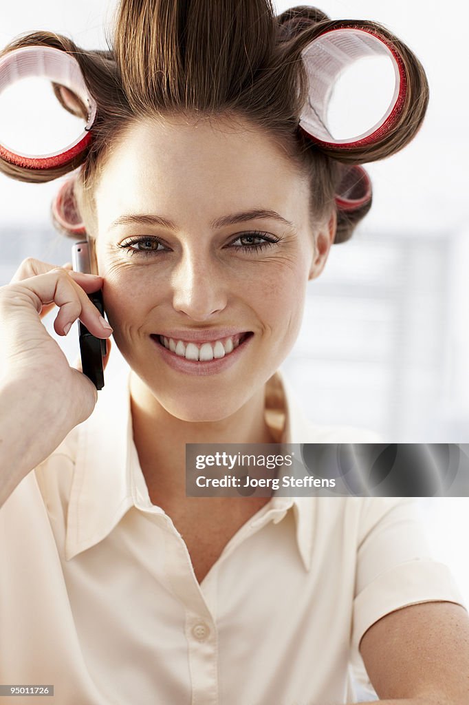 Woman in curlers talking on cell phone