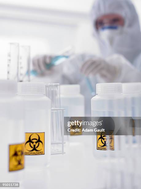 scientist and bottles with biohazard labels - infection control stock pictures, royalty-free photos & images