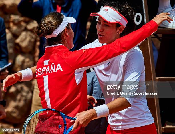 Garbine Muguruza and Anabel Medina captain of the Spanish team embrace after winning the game against Veronica Cepede of Paraguay during day two of...