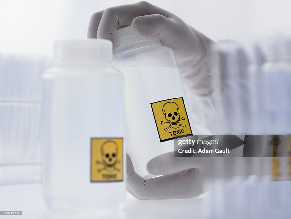 Scientist holding bottle with toxic label