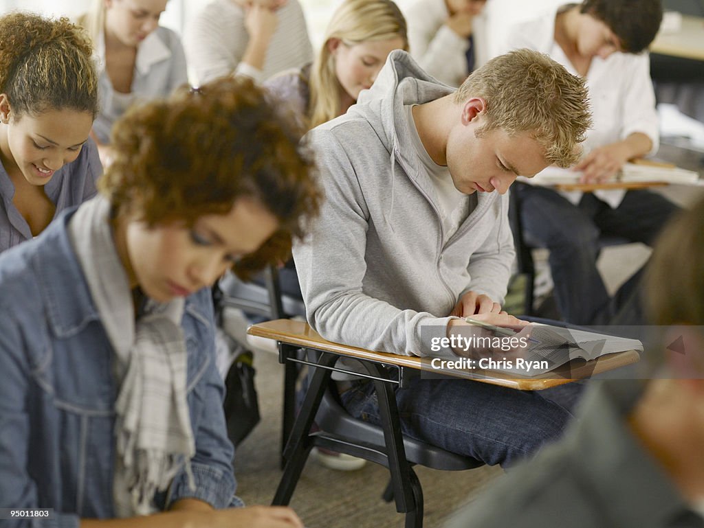 College students reading at desks in classroom