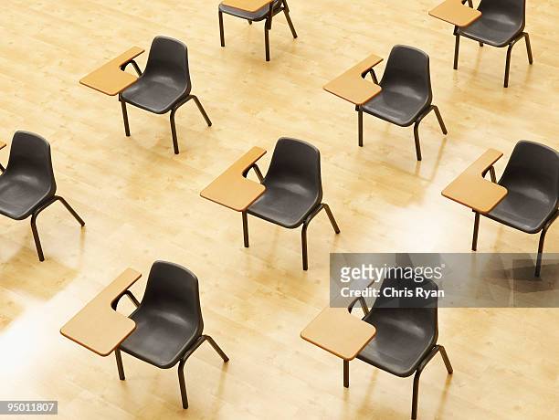 desks in empty classroom - tentamenzaal stockfoto's en -beelden