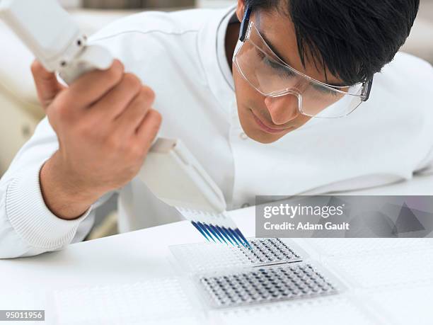 scientist dropping liquid in tray - adam gault stock pictures, royalty-free photos & images