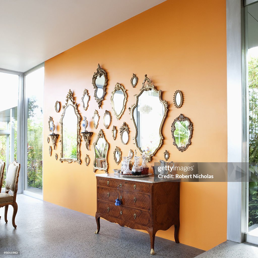 Mirrors on orange wall