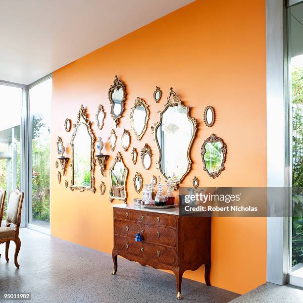 mirrors on orange wall - wall mirror stock pictures, royalty-free photos & images