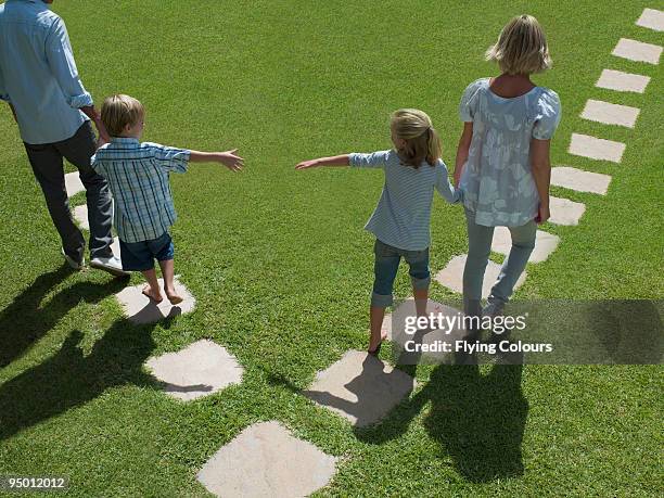 father and son separating from mother and daughter - divided imagens e fotografias de stock