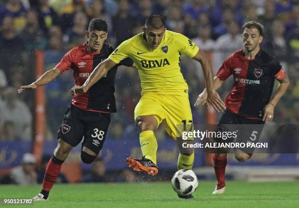 Boca Juniors' forward Ramon Abila controls the ball past Newell's Old Boys' midfielders Braian Rivero and Hernan Bernardello during their Argentina...