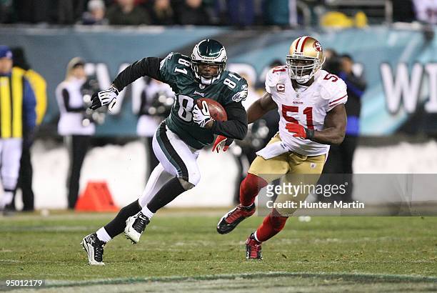 Wide Receiver Jason Avant of the Philadelphia Eagles runs with the ball after catching a pass as linebacker Takeo Spikes of the San Francisco 49ers...