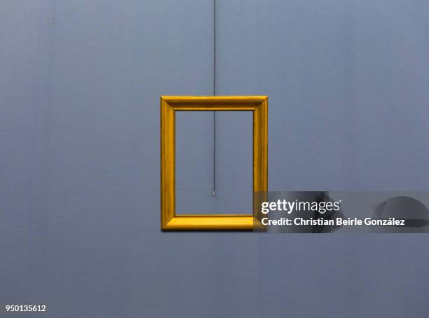 empty frame on blue wall - christian beirle fotografías e imágenes de stock