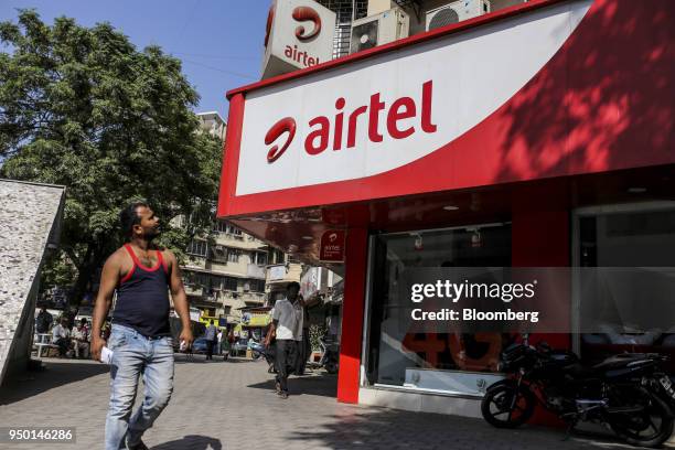 Pedestrian looks up while walking past a Bharti Airtel Ltd. Store in Mumbai, India, on Saturday, April 21, 2018. Bharti Airtel are scheduled to...