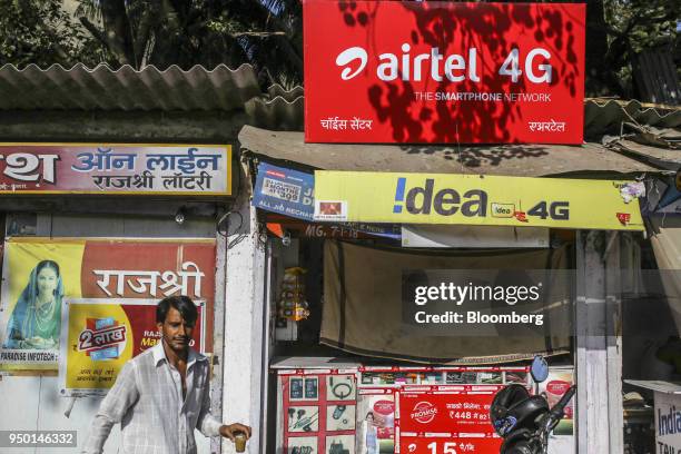 Pedestrian walks past an advertisement for Bharti Airtel Ltd. Outside a sim card store in Mumbai, India, on Saturday, April 21, 2018. Bharti Airtel...