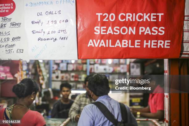 An advertisement for Bharti Airtel Ltd. Is dispalyed above customers at a sim card store in Mumbai, India, on Saturday, April 21, 2018. Bharti Airtel...