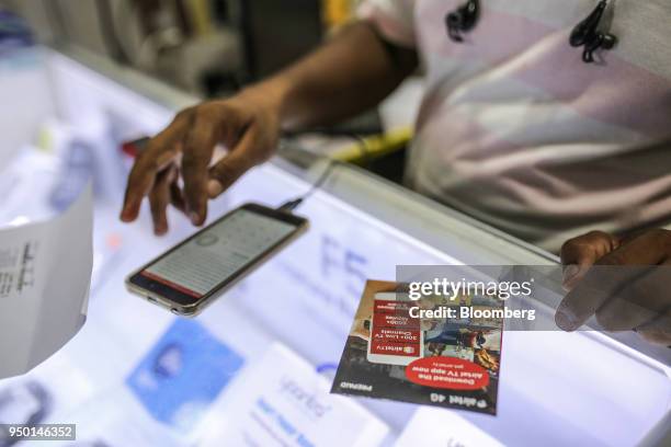 Vendor registers a new data connection on a Bharti Airtel Ltd. App for a customer at a store in Mumbai, India, on Saturday, April 21, 2018. Bharti...