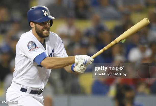 Corey Seager of the Los Angeles Dodgers hits a sac fly to drive in Austin Barnes in the seventh inning against the Washington Nationals at Dodger...