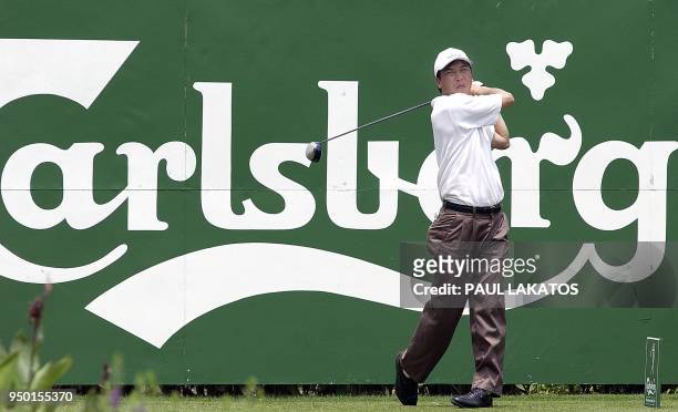 Zhang Lian-wei of China tees off on 19 February 2003 during a practice round for the Carlsberg Malaysian Open at the Mines Resort and Golf Club,...