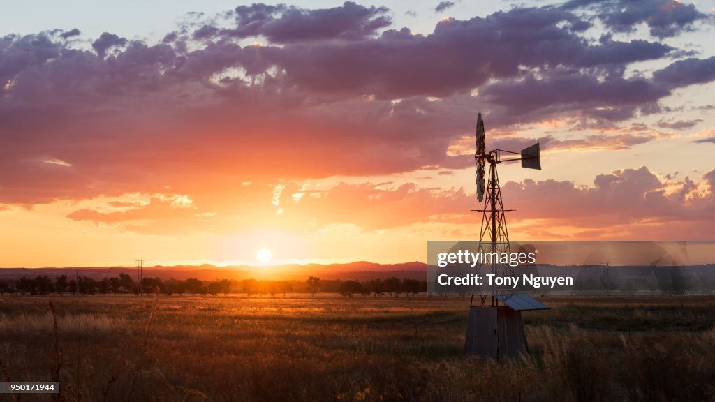 Beautiful sunset beside windmill in rural area, one of the most popular scene in regions in Australia.