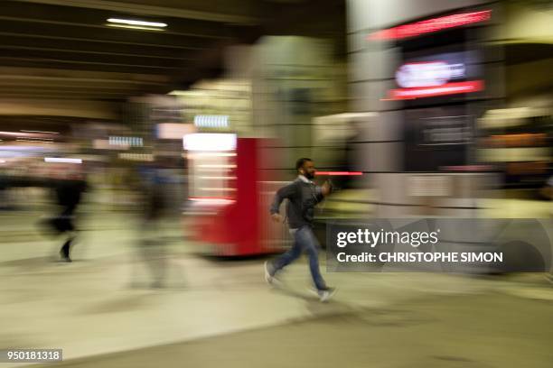 People run to catch at Gare Montparnasse railway station in Paris, on April 23 at the start of two days of strikes by rail workers, the latest in a...