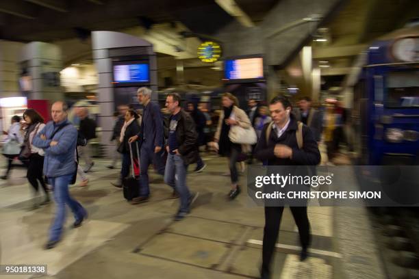 People walk on a platform at Gare Montparnasse railway station in Paris, on April 23 at the start of two days of strikes by rail workers, the latest...