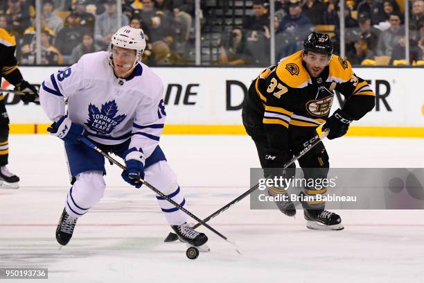 Andreas Johnsson of the Toronto Maple Leafs skates with the puck against Patrice Bergeron of the Boston Bruins during the First Round of the 2018...