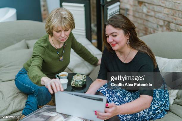 twee vrouwelijke ondernemers, 30 jaar oud en 50 jaar oud, bespreking van sommige project in de moderne vrije stijl kantoor - 50 54 years stockfoto's en -beelden