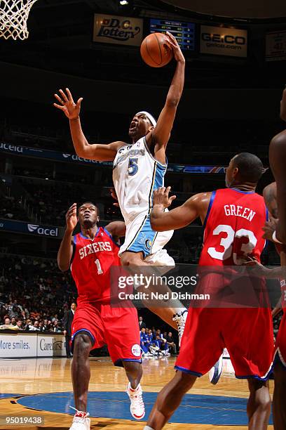 Dominic McGuire of the Washington Wizards shoots against Samuel Dalembert and Willie Green of the Philadelphia 76ers at the Verizon Center on...