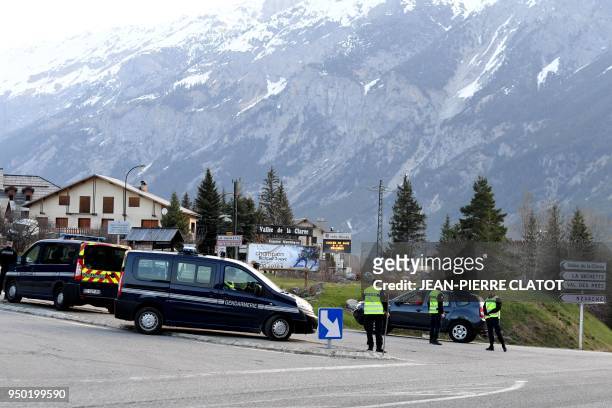French gendarmes control the entrance to the valley of Nevache on April 23, 2018 in Briancon, southeastern France, a route leading to the Col de...