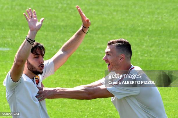 As Roma's players defender Kostas Manolas and striker Edin Dzeko joke as they take part in a training session, on the eve of the Champions League...